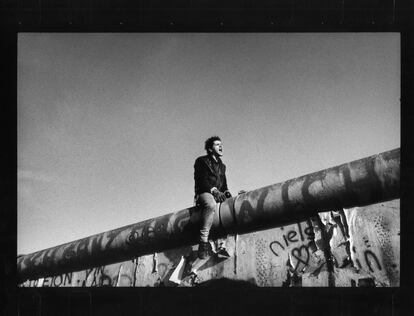 Un joven sentado en el muro entre el este y oeste de Berlén (entret la Puerta de Brandenburg y Potsdamer Platz) 11 noviembre 1989.