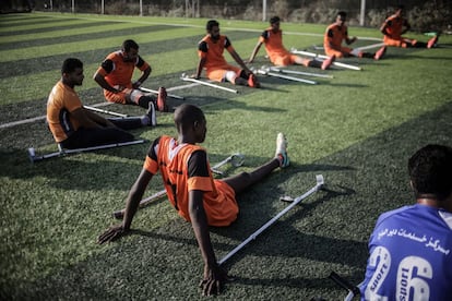 Os jogadores fazem alongamentos durante um treinamento no estádio Deir Ao Balah, no centro da Faixa de Gaza.