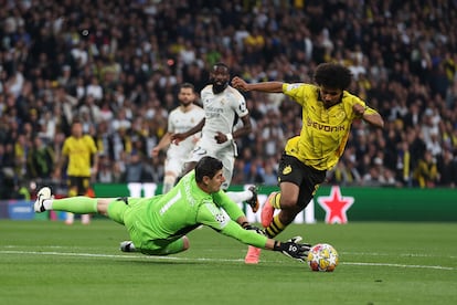 Karim Adeyemi del  Dortmund salva la entrada de Courtois del Real Madrid durante el partido final de la UEFA Champions League.