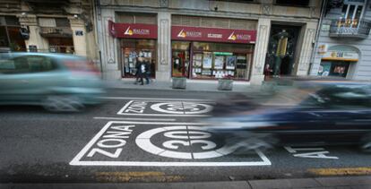 Varios coches pasan por encima de las señales de la calle de la Paz que indican a los conductores la entrada en la zona de limitación de la velocidad.