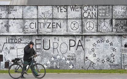 Un hombre pasa junto a un mural artístico sobre Europa en la ciudad de Sibiu.