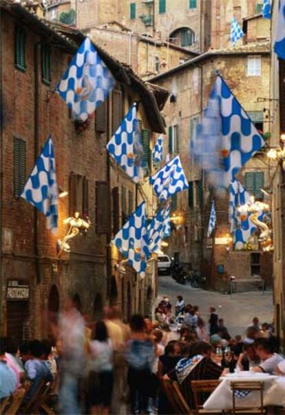 Banquete callejero en Siena antes del Palio, la legendaria carrera de caballos urbana programada el 16 de agosto.