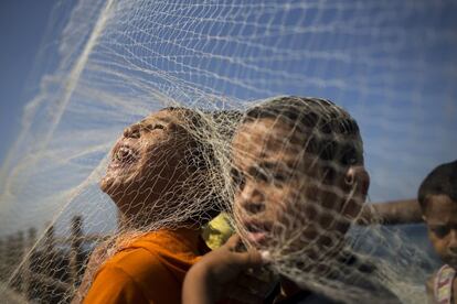 Unos ni?os palestinos juegan con una red de pesca en la playa de la ciudad de Gaza.