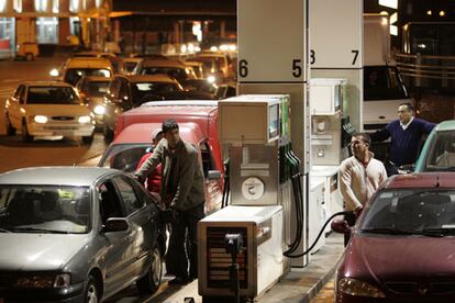 Varios usuarios repostan en la gasolinera junto a Atocha (Madrid), poco antes de medianoche.