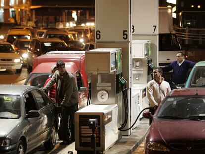 Varios usuarios repostan en la gasolinera junto a Atocha (Madrid), poco antes de medianoche.