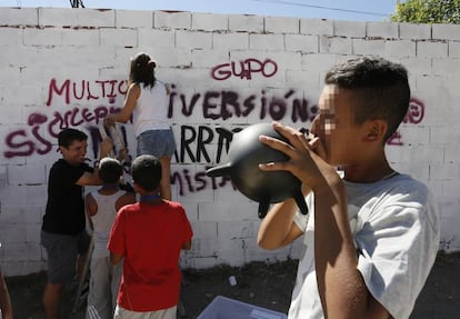 Unos j&oacute;venes pintan un grafiti en la Ca&ntilde;ada Real como parte de un programa de actividades organizadas por Cruz Roja y Obra Social La Caixa.