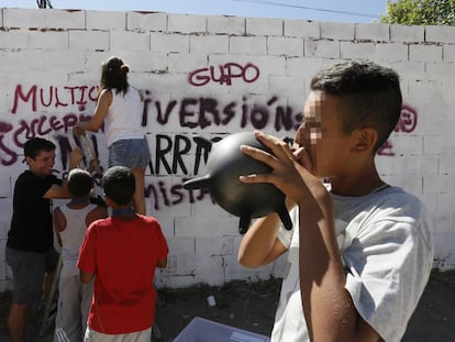 Unos j&oacute;venes pintan un grafiti en la Ca&ntilde;ada Real como parte de un programa de actividades organizadas por Cruz Roja y Obra Social La Caixa.