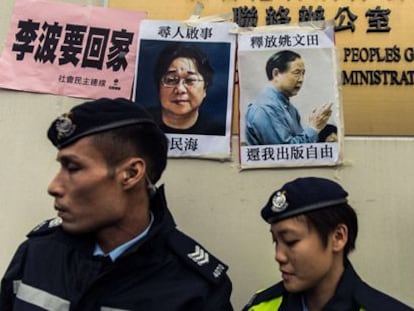 Policías junto a carteles de dos desaparecidos, el domingo en Hong Kong.