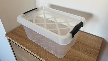 Cajas de plástico para almacenamiento sobre una mesa de madera.