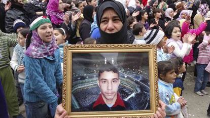 Una manifestante contra El Asad muestra la foto de un desaparecido.