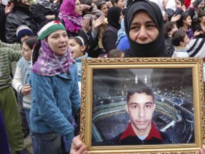 Una manifestante contra El Asad muestra la foto de un desaparecido.