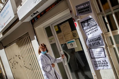 Una sanitaria entra en centro de Salud Palma Norte, en Madrid, lleno de carteles contra la política sanitaria de la Comunidad de Madrid.