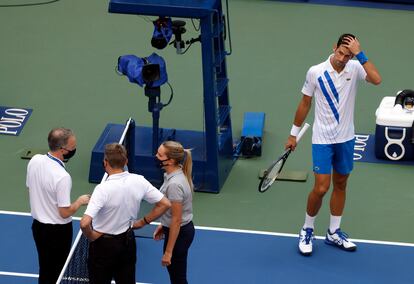 Djokovic observa las deliberaciones de los responsables del arbitraje antes de conocer la descalificación.