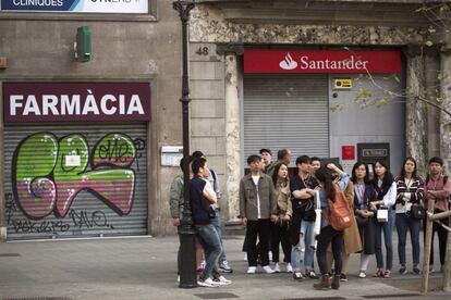 Turistas, junto a varios locales cerrados, durante la jornada de huelga general este viernes en Barcelona.