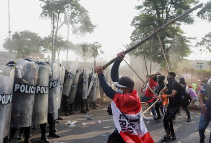 Manifestantes se enfrentan a la policía durante la marcha de este jueves, en Lima.