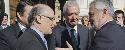 Cristóbal Montoro y José Antonio Griñán se saludan en presencia de Javier Arenas.