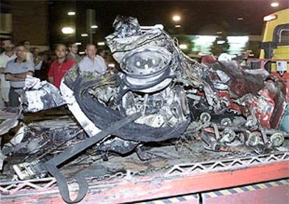 Una grúa retira los restos del coche bomba con el que se realizó el atentado.
