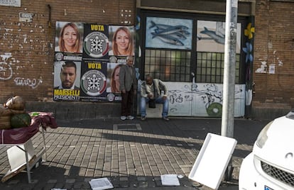 Dos inmigrantes ante los carteles electorale de la candidata fascista en Ostia.