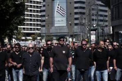 Una multitud de ex agentes de la policía municipal participa en un funeral que simboliza la muerte de la policía municipal, durante una jornada de protestas protagonizada por funcionarios en Atenas (Grecia).