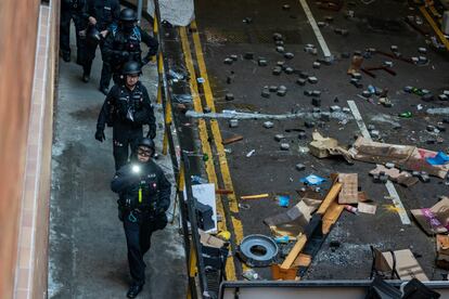 Paredes pintadas con frases como 'Free Hong Kong' (Hong Kong libre), restos de incendios, barricadas formadas por mobiliario escolar y un reguero por las instalaciones de cócteles molotov, máscaras y cascos, mezclados con zapatillas y mochilas estudiantiles. En la imagen, miembros del EOD de Hong Kong (Oficina de eliminación de artefactos explosivos) trabajan en el campus universitario.