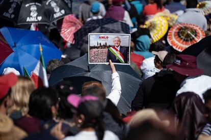 Una mujer sostiene una imagen de López Obrador en medio de la multitud.