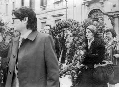 Manuela Carmena sostiene una corona de flores a la salida del Palacio de Justicia durante el funeral celebrado por los abogados laboralistas muertos en la calle Atocha.