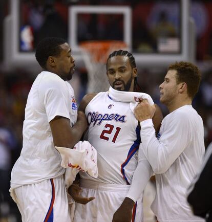 DeAndre Jordan y Blake Griffin celebran con su compañero de equipo Ronny Turiaf, después de que Turiaf hubiera encestado y se le hubiera pitado una falta a su favor a pocos segundos de finalizar el partido.