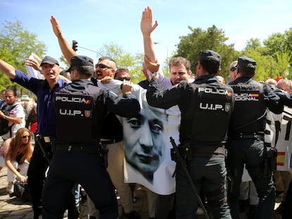 Simpatizantes falangistas forcejean con agentes de policía para intentar entrar en el cementerio de San Isidro a la llegada del féretro con los restos de Primo de Rivera, en Madrid, este lunes.