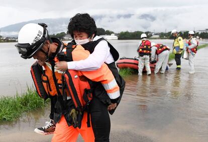 Una residente es rescatada por un bombero tras las fuertes lluvias torrenciales en el área de Asakura, prefectura de Fukouka (Japón).