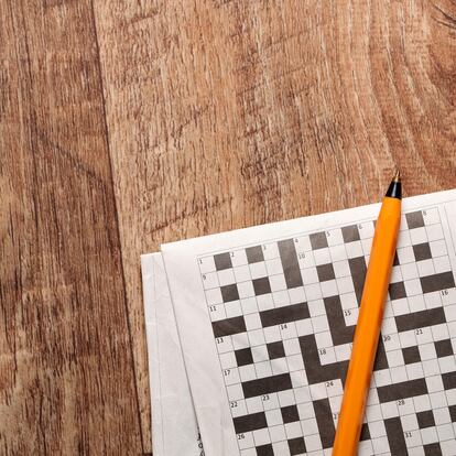 Crossword and pen on a wooden background
