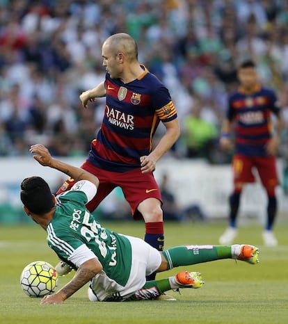 El migcampista brasiler del Betis Petros baralla una pilota amb Iniesta.