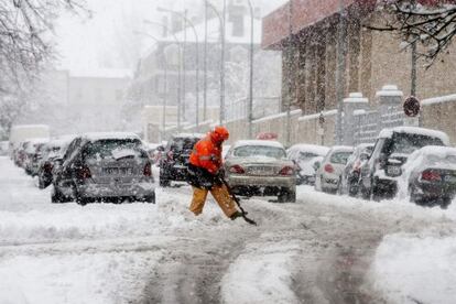 Un hombre limpia trata de despejar de nieve una calle de Vitoria.
