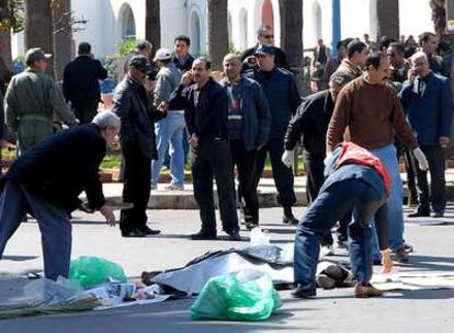 Varios miembros de la policía inspeccionan el cuerpo de uno de los dos terroristas que se suicidaron ayer en Casablanca.
