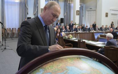 Putin estampa su firma en un globo terráqueo el pasado martes en Moscú.