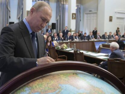 Putin estampa su firma en un globo terráqueo el pasado martes en Moscú.