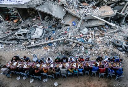 Famílias palestinas se juntam depois de pôr-do-sol para um jantar abundante e rico em nutrientes, necessário para levar adiante, no dia seguinte, o jejum do Ramadã, na Faixa de Gaza, em 18 de maio.