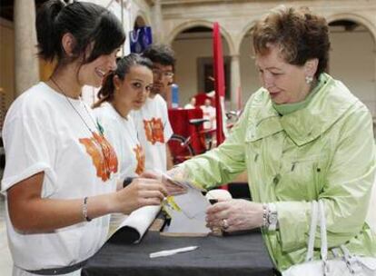 Una vecina de Compostela, que ha comprado cien euros en papeletas, recoge los premios que dará a los niños del Clínico de Santiago.