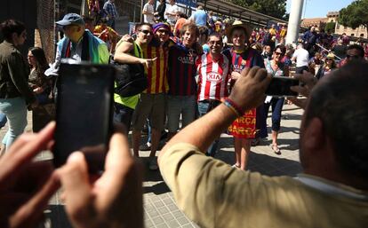 Aficionados del Atlético de Madrid y del FC Barcelona se fotografían juntos en Barcelona.