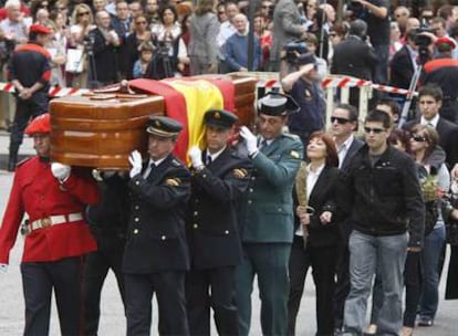 La viuda y los hijos de Eduardo Puelles caminan tras el féretro, llevado por agentes de todos los cuerpos policiales, desde la capilla ardiente a la iglesia que acogió el funeral.