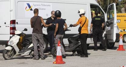 Agentes de la policía analizan varias motos hoy en la Línea de la Concepción con un escáner móvil instalado en una furgoneta.