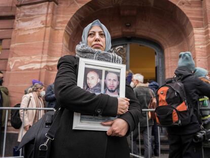 La activista siria Yasmen Almashan muestra imágenes de víctimas del régimen sirio a las puertas del juzgado de Coblenza que ha condenado a Anwar Raslan.