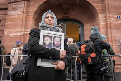 La activista siria Yasmen Almashan muestra imágenes de víctimas del régimen sirio a las puertas del juzgado de Coblenza (Alemania) que condenó en 2022 a Anwar Raslan.