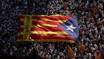 Manifestantes portan una estelada gigante en Barcelona en una celebración de la Diada.