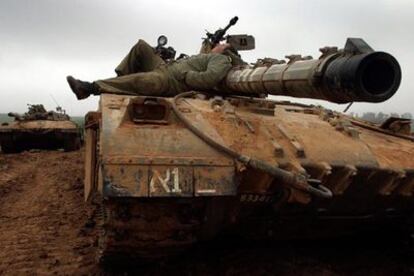 Un soldado israelí descansa sobre un tanque cerca del <i>kibbutz</i> Mefalsim, al norte de Gaza.