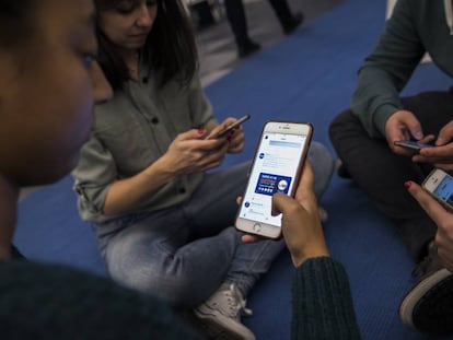 Jóvenes viendo redes sociales en su teléfono móvil.