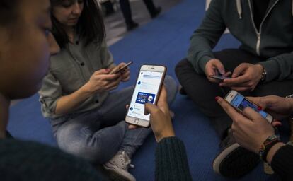 Jóvenes viendo redes sociales en su teléfono móvil.