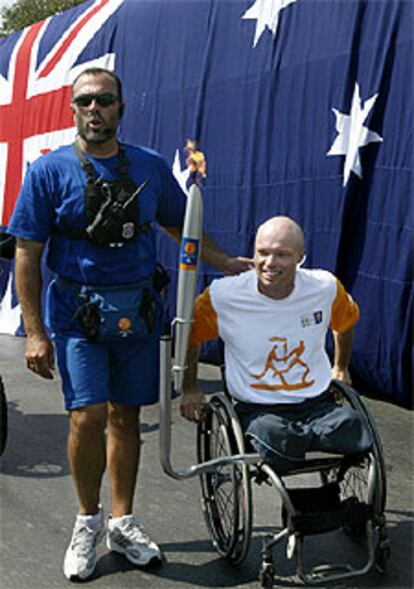 El australiano David Hall, oro en tenis en Sidney, porta ayer la antorcha olímpica.