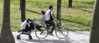 Una pareja pasea en bici con el carrito del bebé. EFE/Archivo