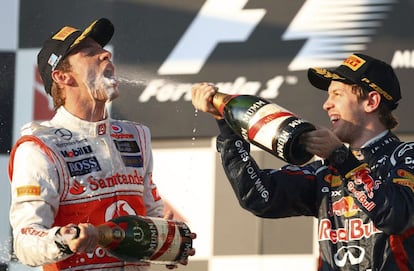 Jenson Button celebra con champán su victoria junto a Sebastian Vettel