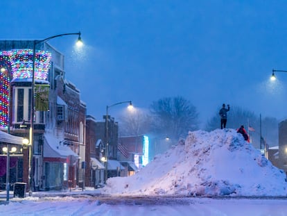 People play on an large snow pile in Oskaloosa, Iowa, Tuesday, Jan. 9, 2024.